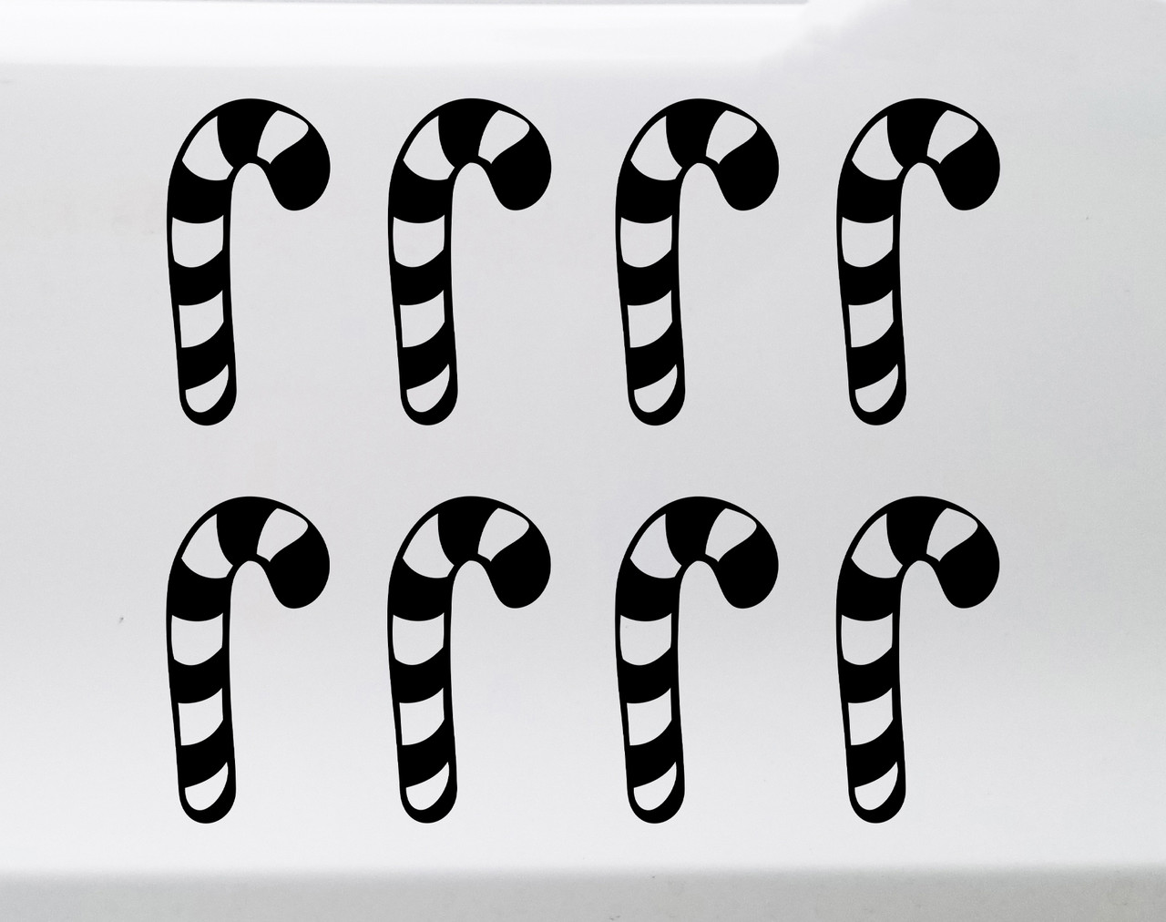 Set of eight striped candy cane Christmas vinyl decals arranged in two rows of four on a glass window, featuring traditional curved hooks and peppermint stripe cutouts