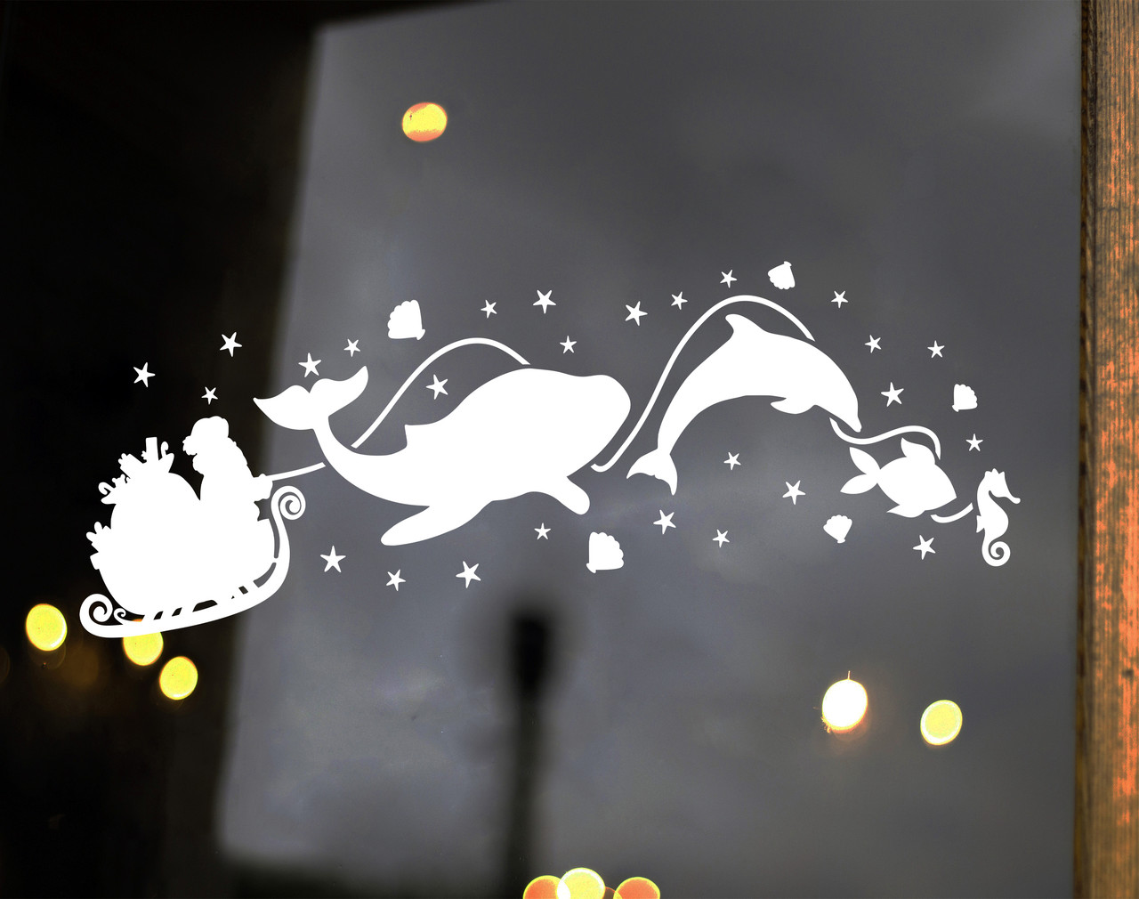 White Christmas vinyl window decal featuring Santa Claus in a sleigh pulled by a whale, dolphin, fish and seahorse surrounded by stars and seashells