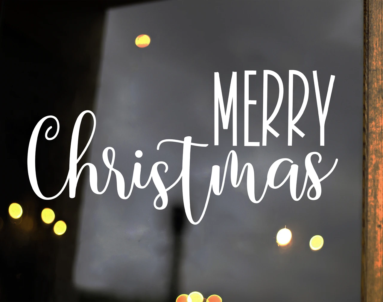Merry Christmas vinyl window decal featuring tall uppercase MERRY lettering above flowing cursive Christmas script with decorative flourishes
