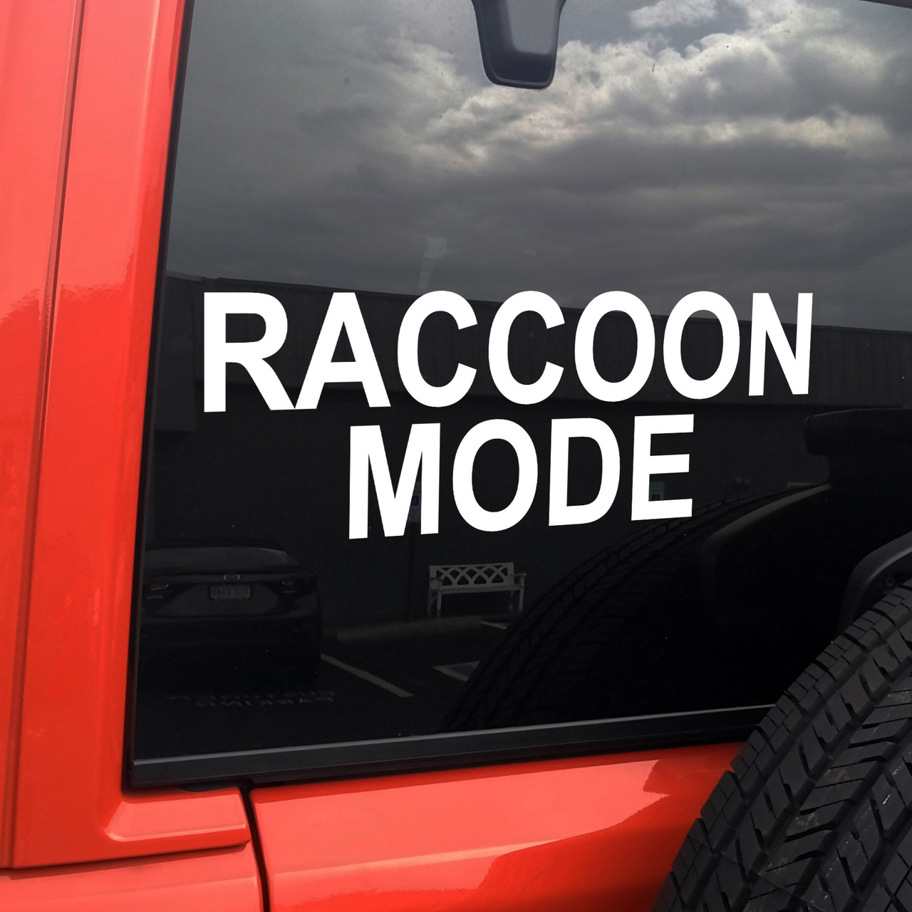 Raccoon Mode vinyl decal featuring bold black text with playful chaotic meme styling on a clean white background