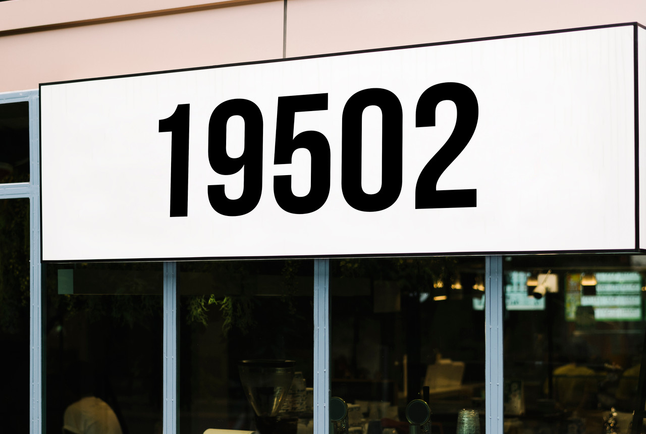 Large storefront address numbers vinyl decal in Bebas Neue font with modern minimalist business signage style
