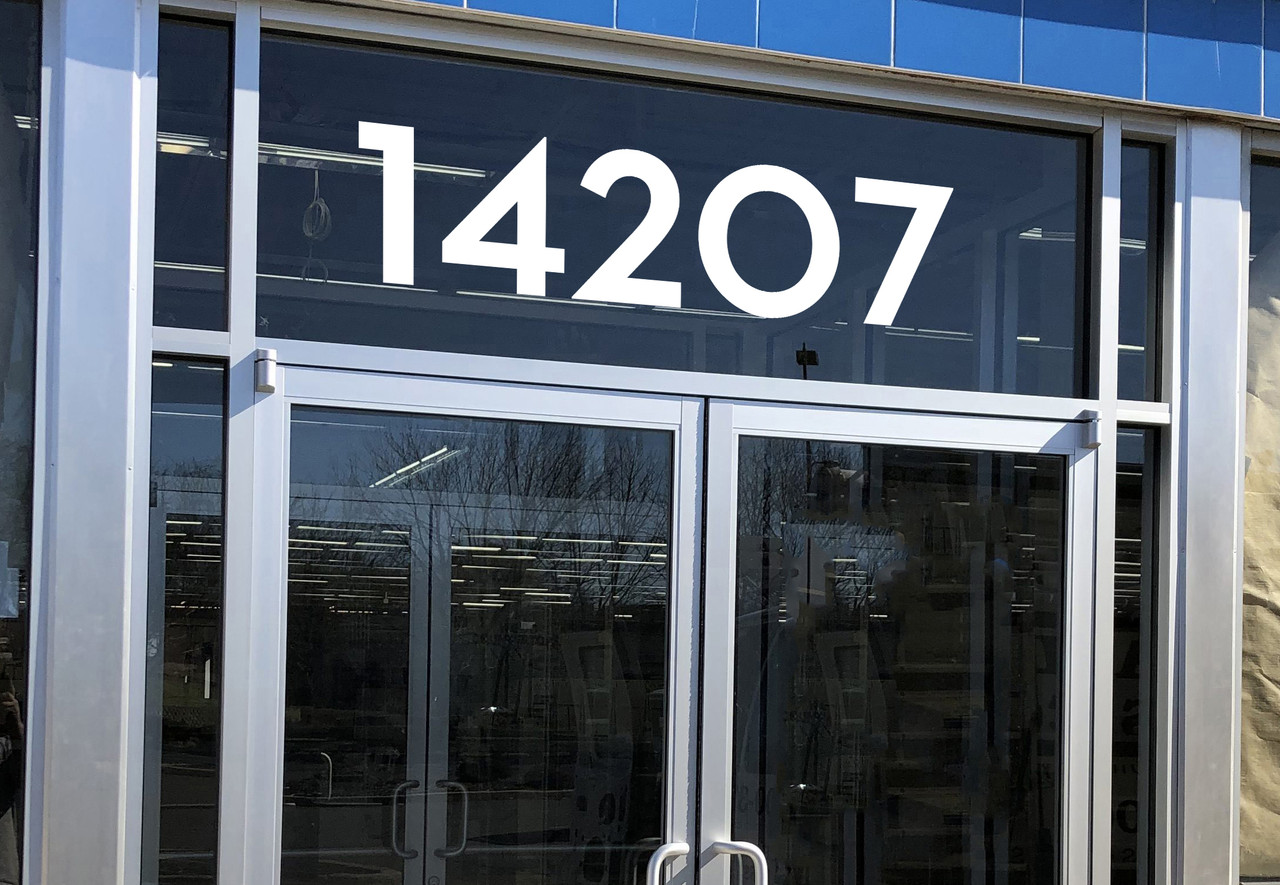 Neutra Display font storefront address numbers vinyl sticker decal applied to a business window with clean geometric lettering