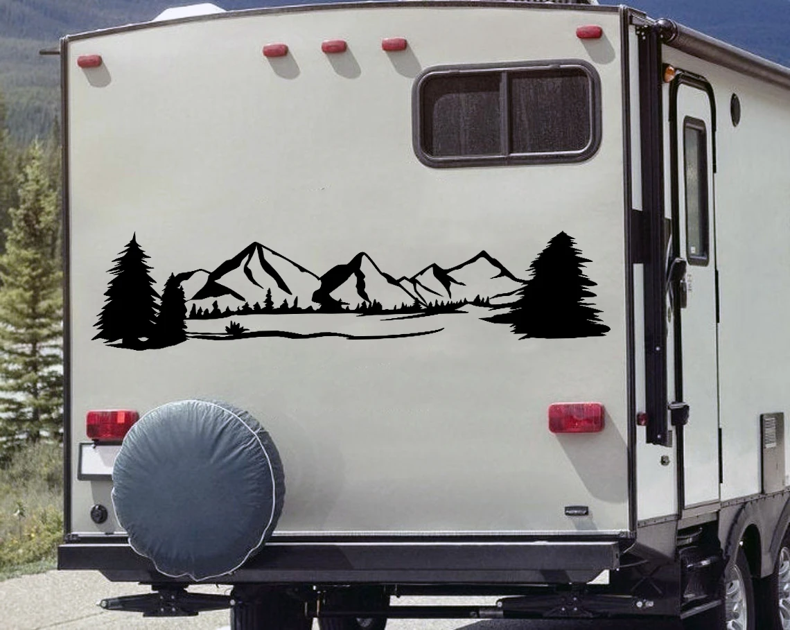 Mountain forest scene vinyl sticker decal applied to RV travel trailer window with pine trees and wilderness landscape design