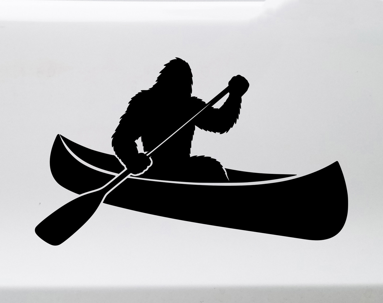 bigfoot sasquatch paddling canoe vinyl sticker decal applied to car window showing outdoor lake adventure silhouette