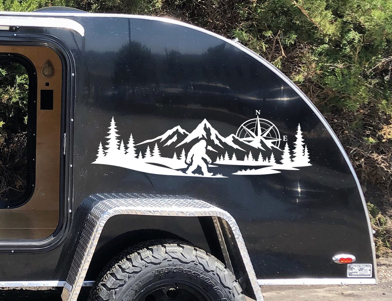 bigfoot sasquatch compass mountain forest vinyl sticker decal applied to rv window showing wilderness adventure silhouette design