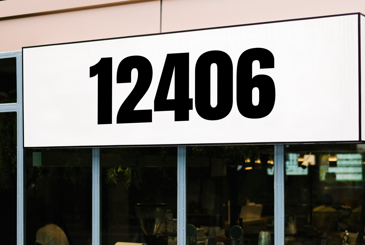large Anton font vinyl storefront numbers applied to modern business window with bold condensed geometric typography