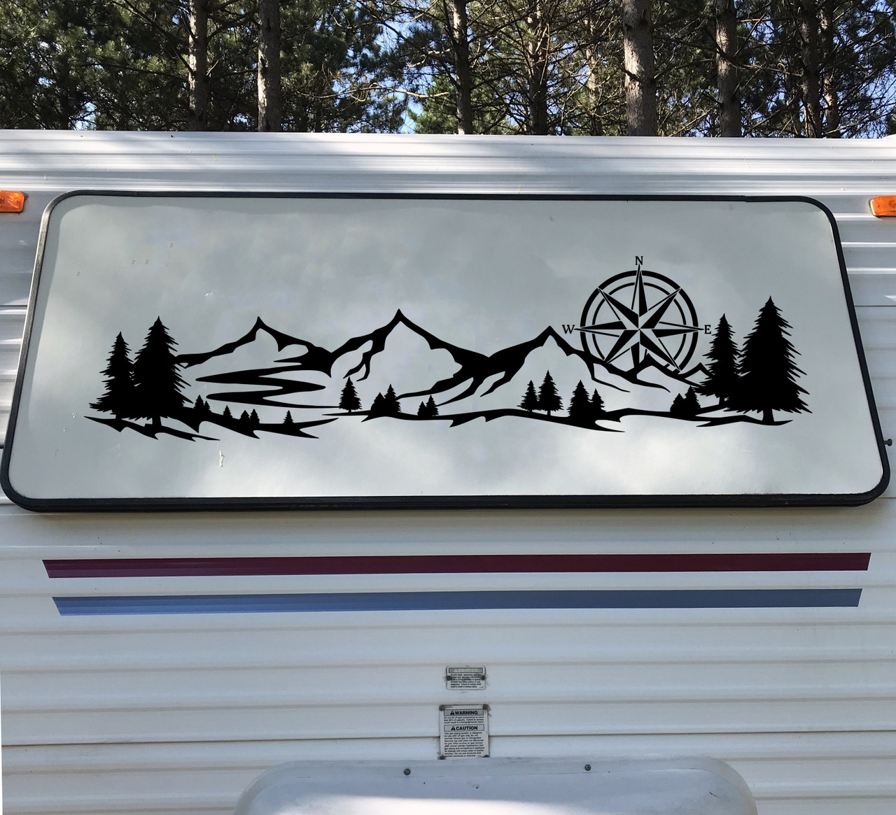 mountain compass rose vinyl sticker decal applied to rv camper rear window with outdoor wilderness adventure design