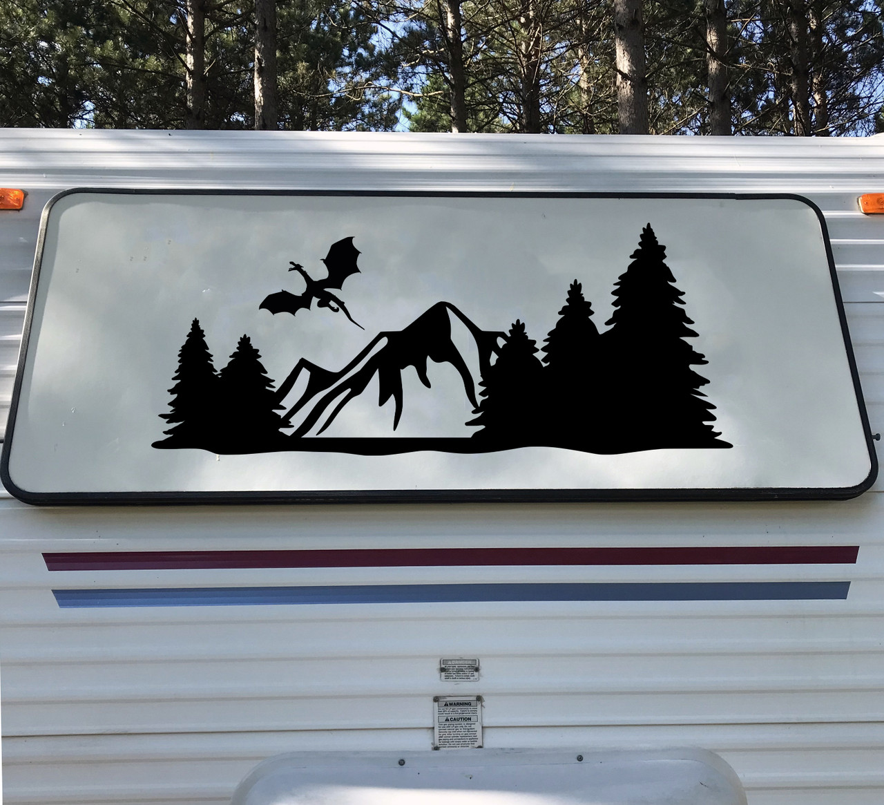 mountain dragon vinyl sticker decal featuring a flying dragon above rugged mountain peaks and pine forests designed for rvs campers travel trailers and teardrop campers