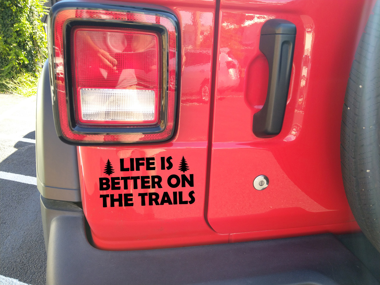life is better on the trails vinyl decal featuring pine trees and bold lettering designed for trucks, suvs, campers, overland rigs, and outdoor adventure vehicles