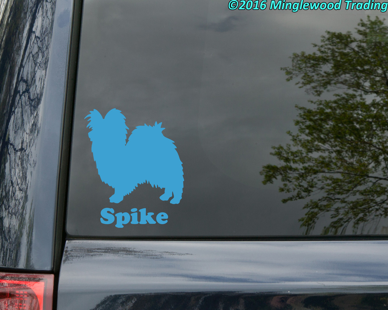 Personalized Papillon Butterfly Dog silhouette vinyl decal with custom name underneath, shown with the name Spike on a vehicle window, available in six sizes from 4 x 4.5 inches to 20 x 23 inches with mirror option and 15-character name personalization