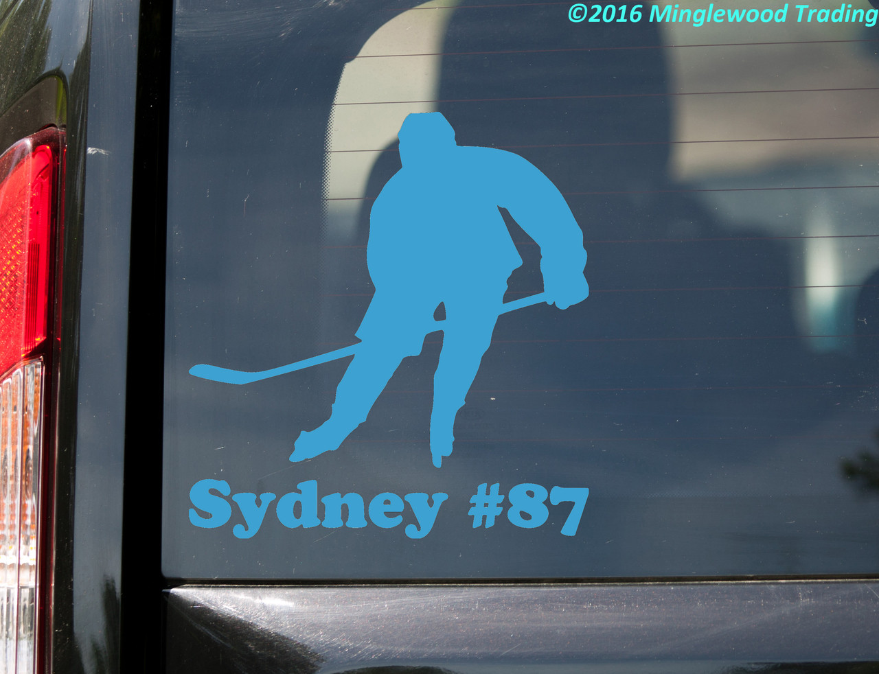 personalized ice hockey player vinyl decal featuring a skater holding a hockey stick with custom name Sydney and jersey number 87 beneath the silhouette, displayed on a red truck window, available in four sizes with mirror option