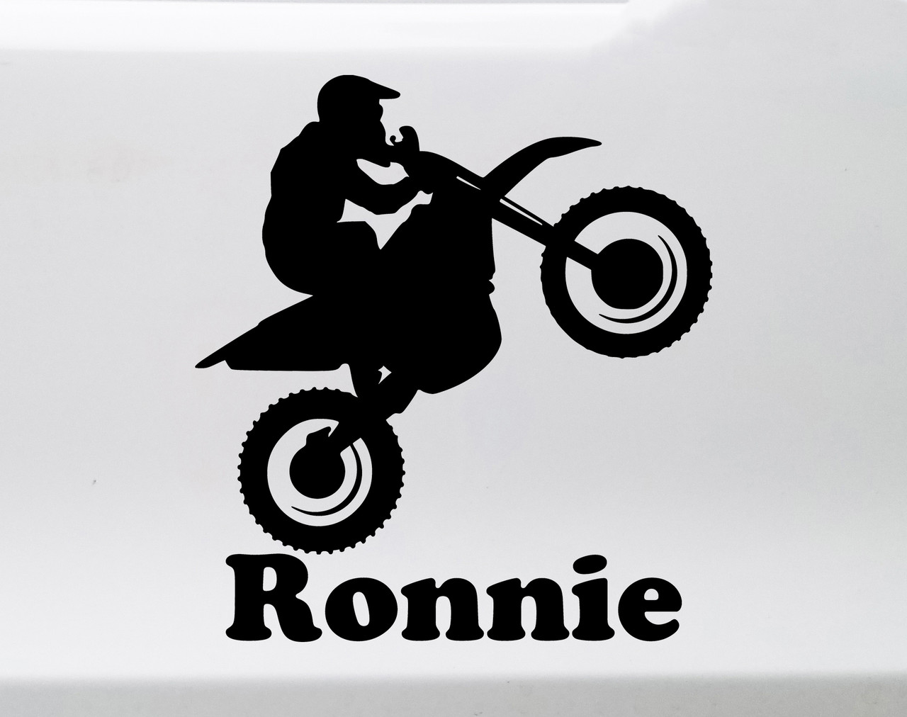 Personalized dirt bike vinyl decal featuring motocross rider doing a wheelie with custom name and racing number