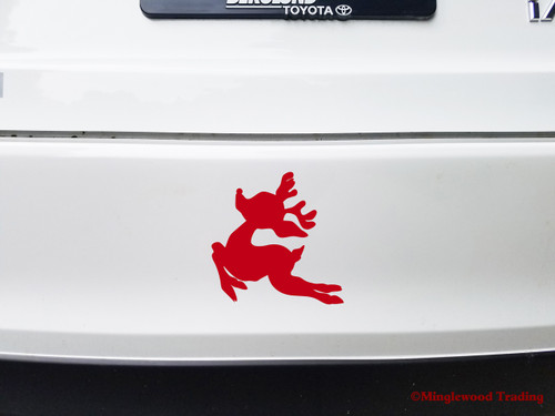 Leaping Christmas reindeer silhouette vinyl decal with antlers displayed on truck window for holiday decorating
