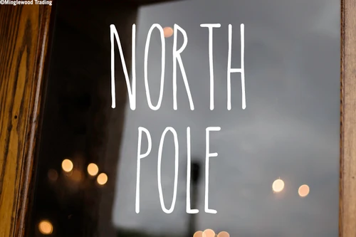 North Pole Christmas vinyl decal featuring tall skinny farmhouse style handwritten lettering arranged in two lines on glass window