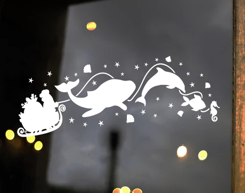 White Christmas vinyl window decal featuring Santa Claus in a sleigh pulled by a whale, dolphin, fish and seahorse surrounded by stars and seashells