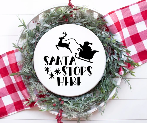 White Santa Stops Here Christmas vinyl window decal featuring Santa Claus in a sleigh pulled by a reindeer above decorative holiday lettering and stars