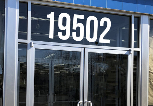 Large storefront address numbers vinyl decal in Bebas Neue font with modern minimalist business signage style