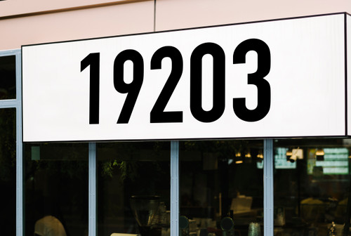 Large storefront address numbers vinyl decal in DIN 1451 font with modern minimalist business signage style