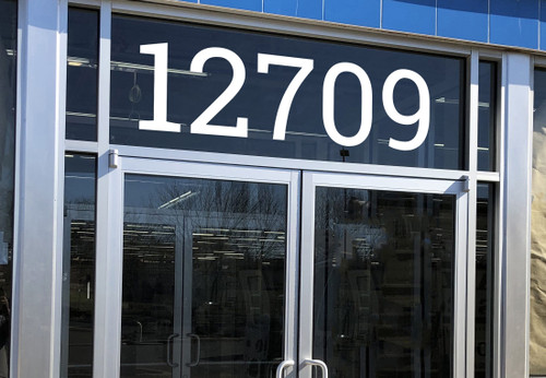 large Roboto Slab vinyl storefront numbers applied to modern business window with geometric serif typography