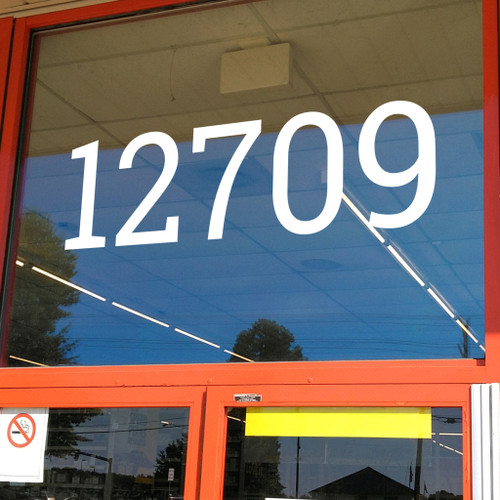 large Roboto Slab vinyl storefront numbers applied to modern business window with geometric serif typography