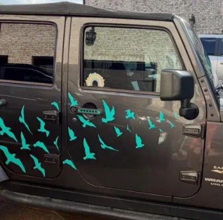 25 flying bird vinyl decal set arranged across Jeep doors and vehicle body panels
