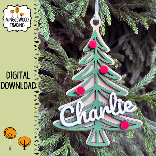 Personalized Christmas tree ornament SVG laser cutting design featuring layered evergreen branches, decorative round ornaments, hanging loop, and example name Charlie across the front