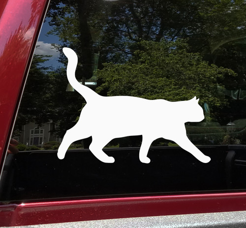 White walking cat silhouette vinyl decal featuring a feline with raised curved tail and extended front paw, shown on a vehicle window, available in 11 sizes from a 4-pack of 2 x 1.5 inches to 30 x 22 inches with standard and mirrored orientation options