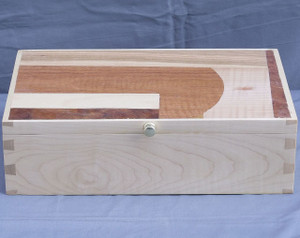 A handcrafted valet box made from light-toned solid curly maple wood, showcasing beautiful rippled grain patterns on the sides and prominent, dark through-dovetail joinery on the corner edges.