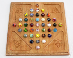 Handcrafted diamond marble solitaire game board carved from solid cherry wood.