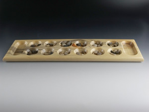 Mancala game in Beetle Kill Pine with the stones in their starting positions.