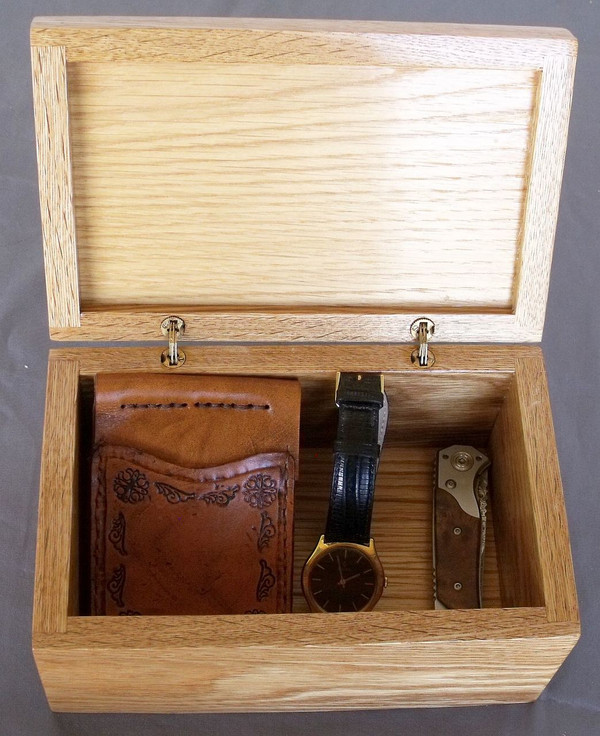 The open box with a wallet, watch, and knife showing the size of the box.  The items pictured inside the box are not included.