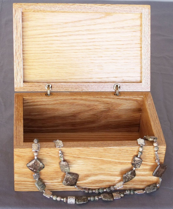 The open box with a necklace draped along the front.  The necklace is not included.