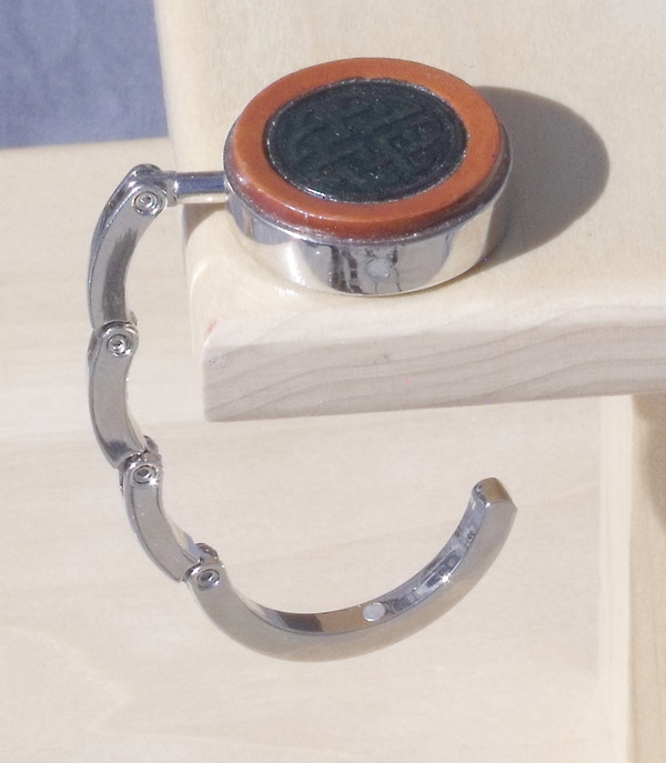 An open purse hook hanging off the edge of a table.