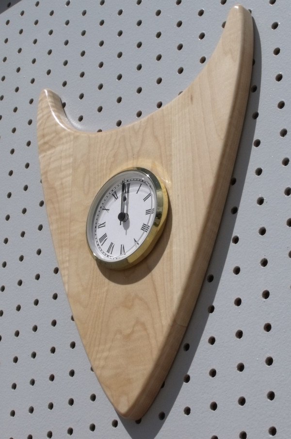 The curly maple wedge clock with the point down  showing the thickness.