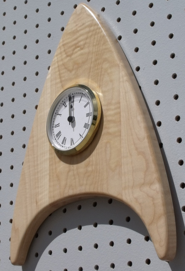 The curly maple wedge clock with the point up showing the thickness.