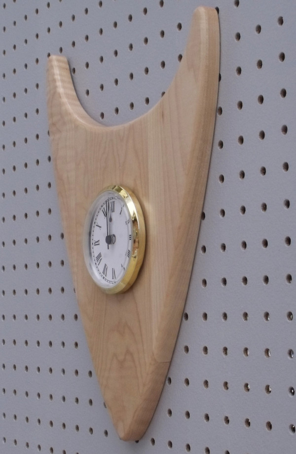 Close-up of the curly maple wedge clock showing the chatoyance of the wood.