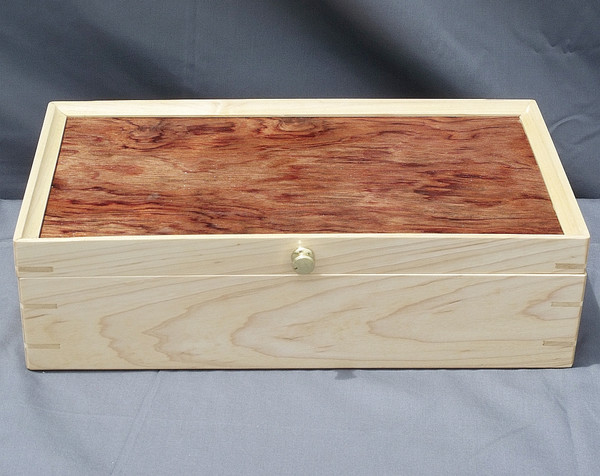 The maple and bubinga keepsake box showing the splines, brass knob, maple front, and bubinga top.