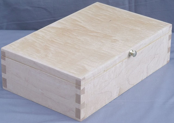 Close up of a solid maple keepsake box lid highlighting the natural shimmering curly wood grain and the mitered corners.