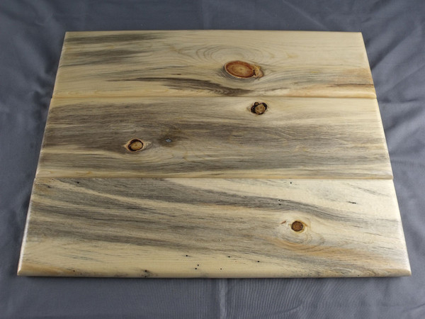 The back of three of the Mancala boards showing the different grain and color patterns inherent to the natural wood