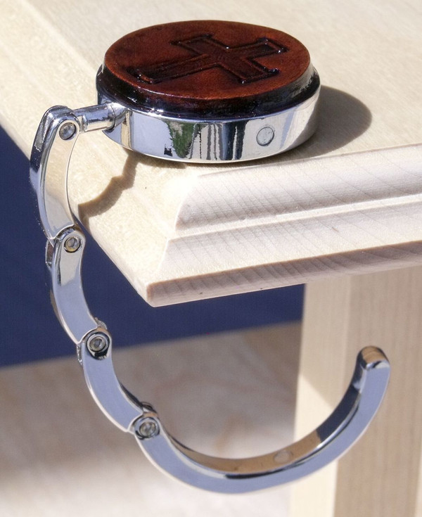 An open purse hook hanging off the edge of a table.