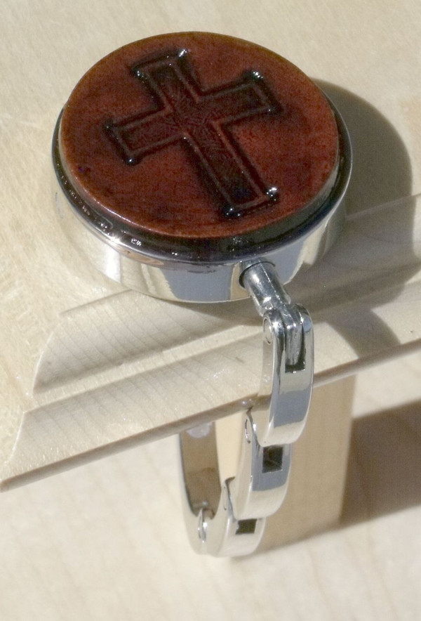 An open purse hook hanging off the edge of a table.