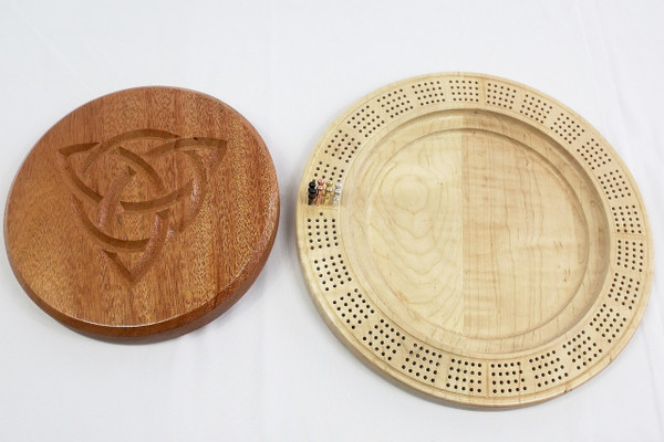 The open cribbage board showing the storage space with the pegs in their starting position.