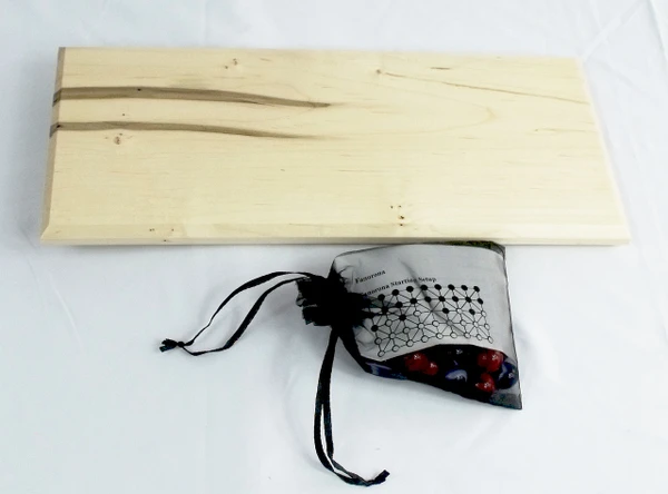 The back of the Fanarona game with the bag containing the marbles, history, and rules.