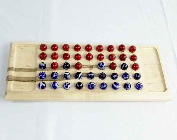 Top view of the maple Fanarona game with red and blue marbles.