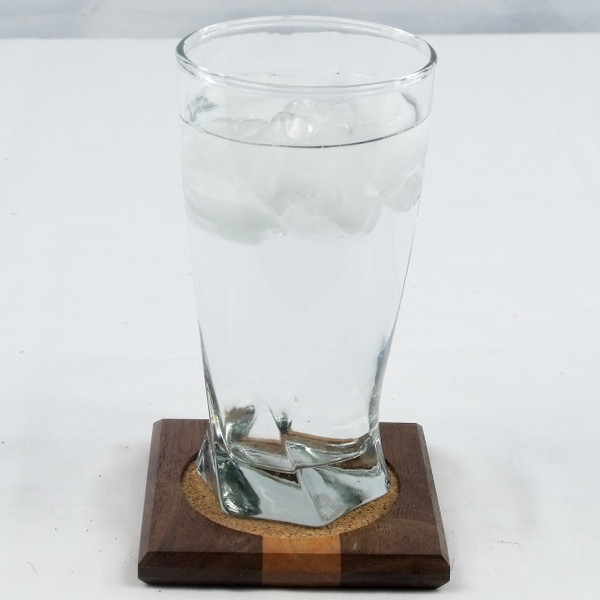 A coaster with a glass of ice water on it.
