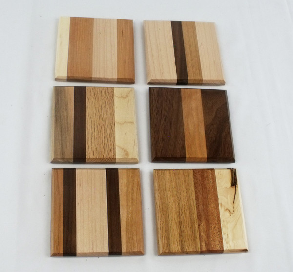 The backs of six coasters set out side-by-side, showing the side without the cork insert.  No two coasters are the same.  This is an example of the coasters.  The actual product you receive will differ.