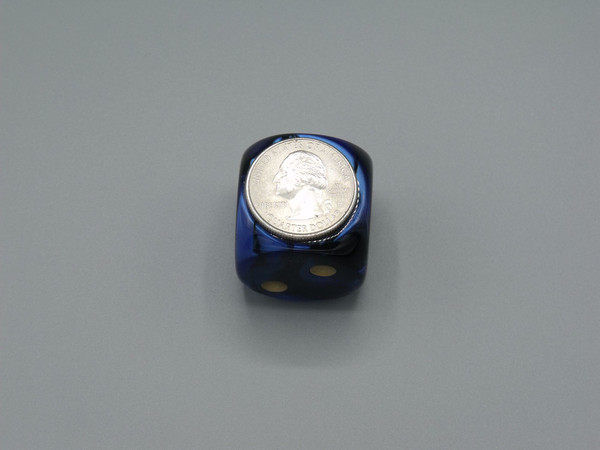 One 30mm Gemini Black-Blue die with a quarter on top for size.
