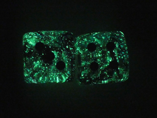 Two dice glowing in the dark.