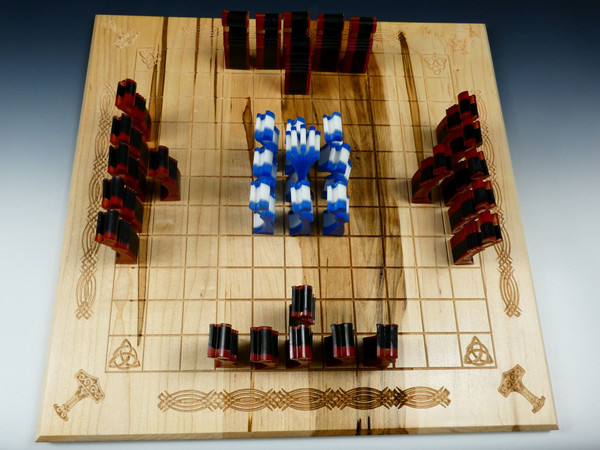 A top-down view of the Hnefatafl board with the poured resin pieces in their starting positions.
