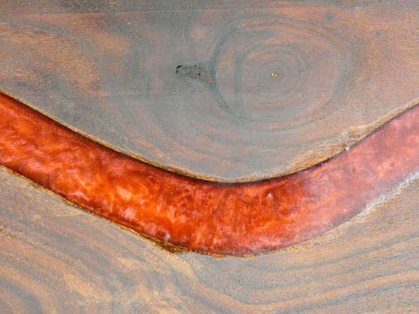 A close up of the walnut serving board with red epoxy resin.